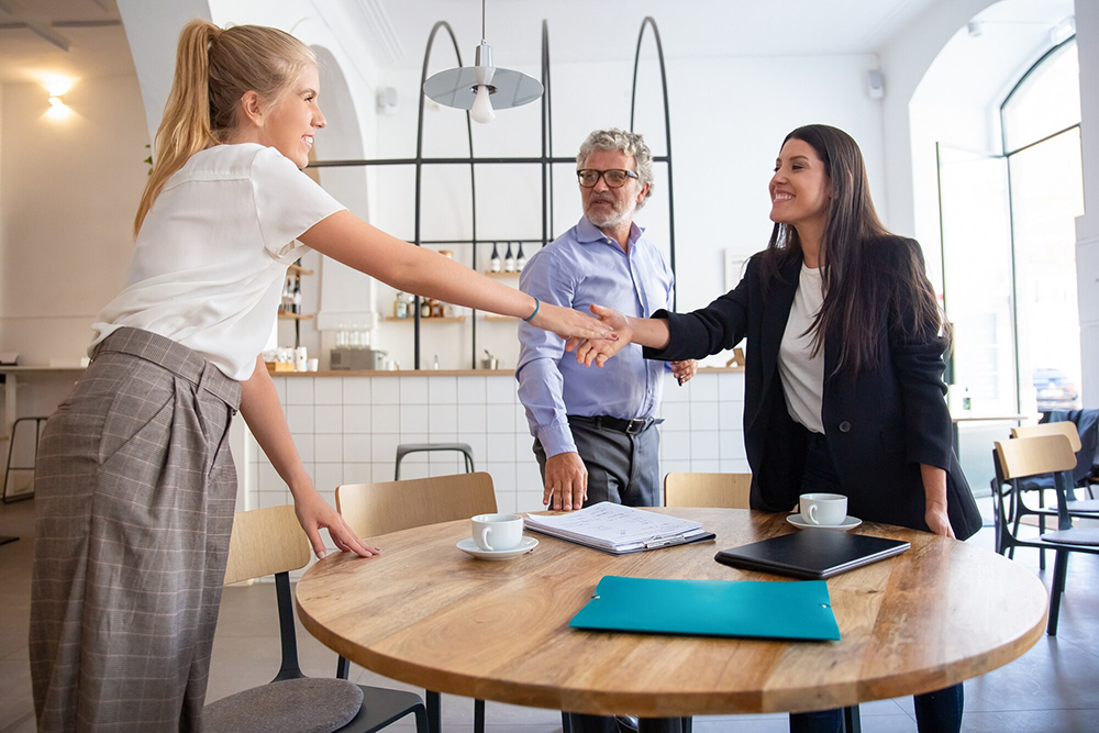 successful-female-business-professional-meeting-with-customers-shaking-hands_74855-10411